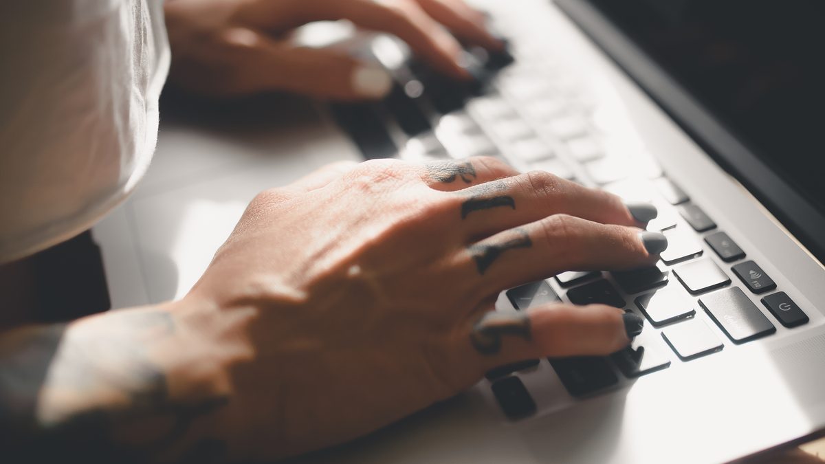 Hands typing on a laptop keyboard