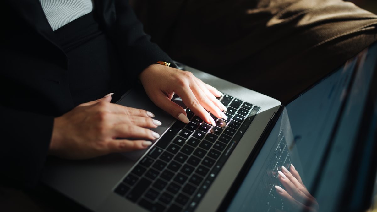 Hands typing on a laptop keyboard